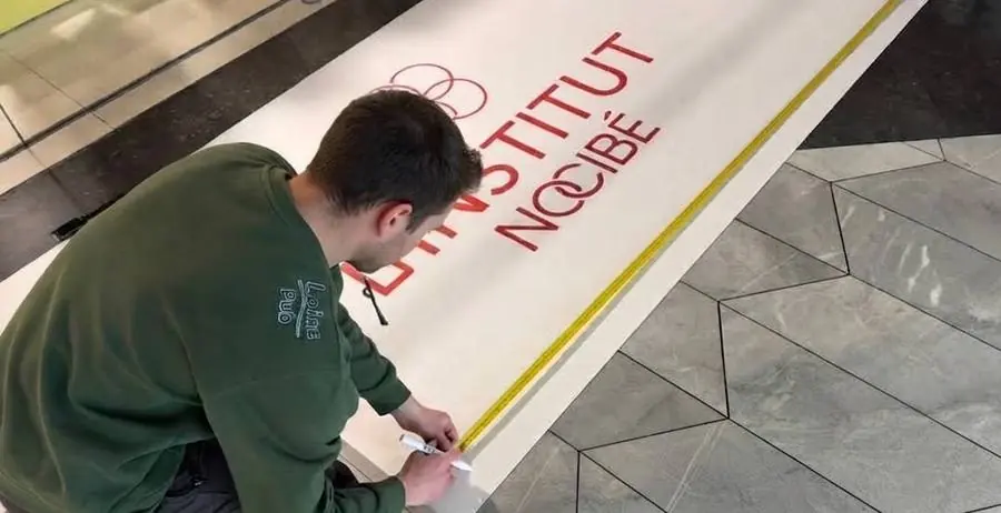 Technicien Loire Pub posant une vitrophanie au sol pour l'Institut Nocibé